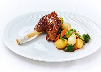 Lamb shank soaked in red wine with a side dish of seasonal vegetables