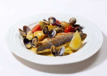 Sea bass fillet with vongole, artichokes, young potatoes and tomatoes