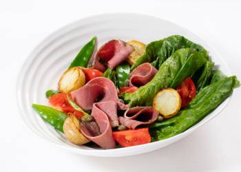Salad with pastrami, young potatoes, romano leaves and mustard dressing